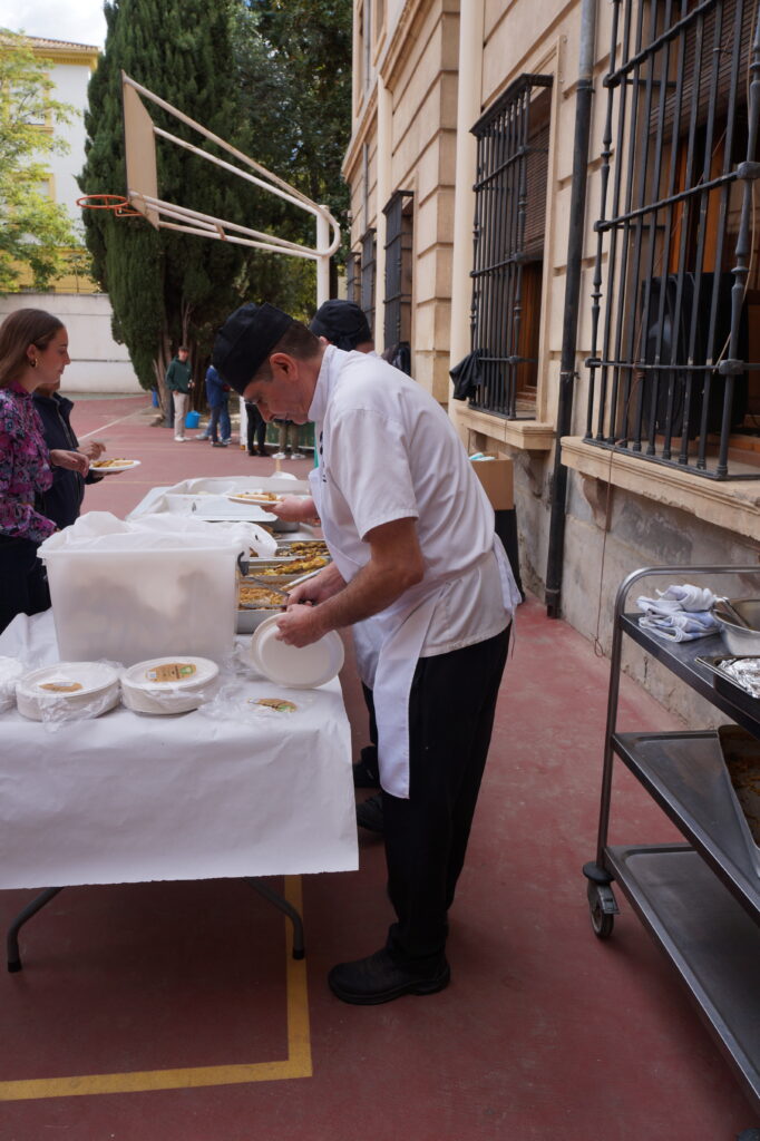 Los cocineros repartiendo paella y pinchos